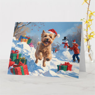 Wheaten Terrier läuft im Schnee mit Weihnachtsmütz Karte