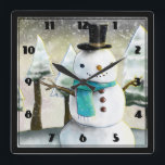 Whimsical Snowman Winter Scene Christmas Drawing Quadratische Wanduhr<br><div class="desc">Clock with a cute drawing featuring a snowman wearing a cool top hat and scarf. The background has a line of whimsical snow-covered pine trees.</div>