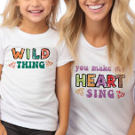 Wilde Dinge, die mich dazu bringen, mein Herz zu s T-Shirt<br><div class="desc">'wilde Sache' Kinder T - Shirt mit dem passenden 'macht mein Herz singen' Mama T - Shirt Version verfügbar. Dieses farbenfrohe Typografie-Design zeichnet sich durch eine kurvige, moderne Retroschrift aus und zeichnet sich durch eine farbenfrohe, mit Lieben verzierte Zeichnung aus. Ein lustiges Zitat, aufgeteilt in Mutter- und Kinderoutfit, das auch...</div>