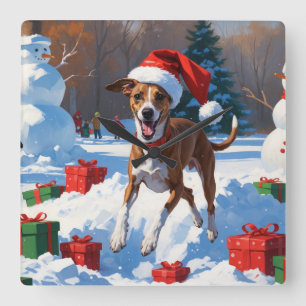 Windhund läuft im Schnee mit Weihnachtsmütze Quadratische Wanduhr
