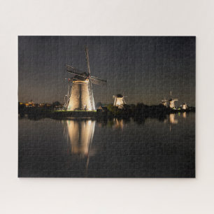 Windmills and water illuminated at night