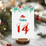Winter Greenery Weihnachtsmannmütze Weihnachtsthem Tischnummer<br><div class="desc">Fügen Sie Ihrem Feiertag mit dieser Winter Greenery Weihnachtsmannmütze Weihnachtsthema Tischnummer festlichen Charme hinzu. Das Design besticht durch eine elegante Winterlandschaft und eine niedliche Weihnachtsmannmütze auf weißem Hintergrund. Freuen Sie sich auf ein fröhliches und stilvolles Weihnachtsbild. Ideal für Hochzeitsabende,  Babydusche,  Feierlichkeiten oder festliche Ansammlungen.</div>