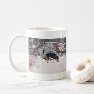 Winterschneeszene mit niedlichem schwarzem und tan kaffeetasse