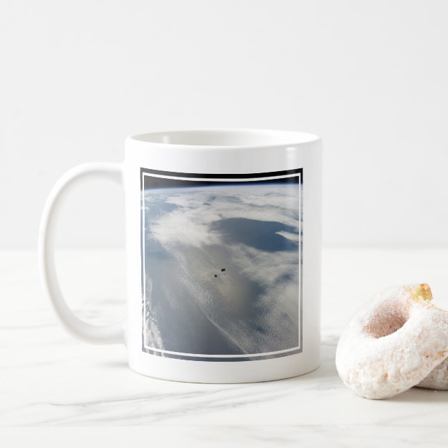 Winzige Satelliten umkreisen über einem Teil der E Kaffeetasse (Mit Donut)