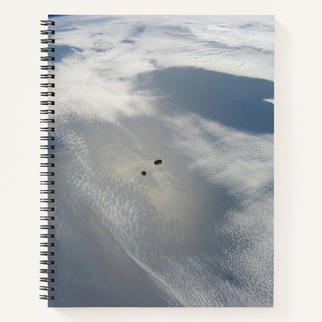 Winzige Satelliten umkreisen über einem Teil der E Notizbuch (Vorderseite)