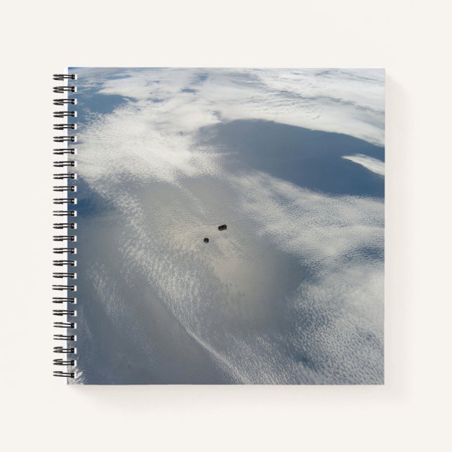 Winzige Satelliten umkreisen über einem Teil der E Notizbuch (Vorderseite)