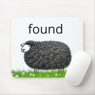 Wolliges schwarzes Schaf im Gras mit gefundenem Te Mousepad