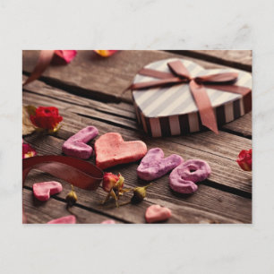 Wort Liebe mit herzförmigem Valentinstag-Geschenk Feiertagspostkarte