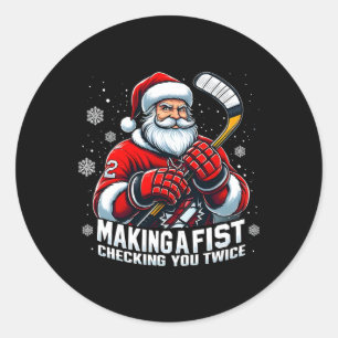 Xmas-Weihnachtsmann-Hockeyspieler, die eine Faust Runder Aufkleber