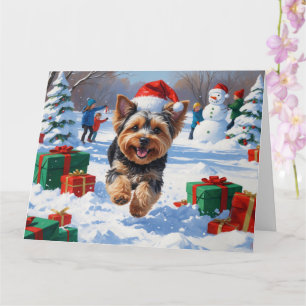 Yorkipoo läuft im Schnee mit Weihnachtsmütze Karte