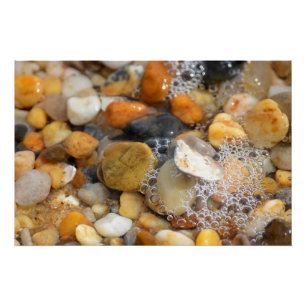 Zahlreiche Felsen an einem Sandstrand mit Wasser Poster