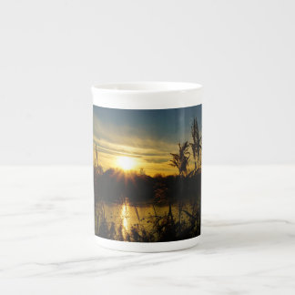 Zonsondergang bij een meertje met rietpluimen. prozellantasse