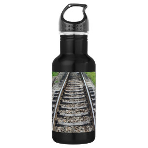 Zug-Bahnen entlang Gras-Nahaufnahme Trinkflasche