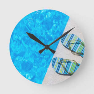 Zwei badenpantoffel auf Rand des Swimmingpools Runde Wanduhr