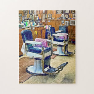 Zwei Barberstühle mit rosa gestreiften Barberkappe