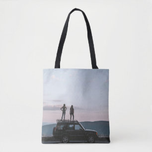 Zwei Frauen auf dem Dach des Autos stehend Tasche