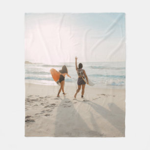 Zwei Frauen, die zum Ozean laufen und surfen Fleecedecke