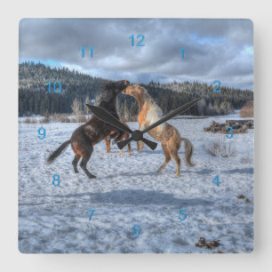Zwei Ranch-Pferde spielen im Winterschnee IV Quadratische Wanduhr