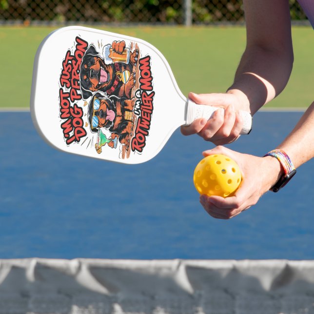 Zwei Rottweiler-Hunde sitzen zusammen Pickleball Schläger (InSitu)
