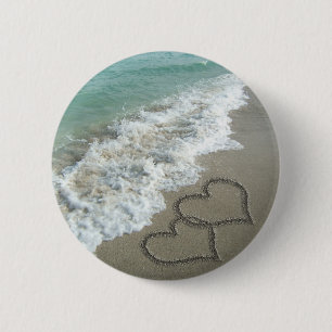 Zwei Sand-Herzen auf dem Strand Button
