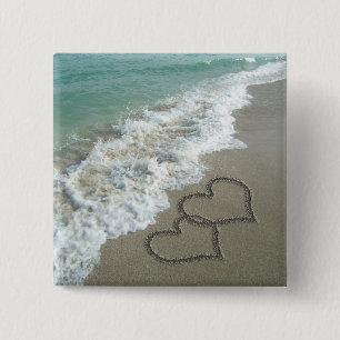 Zwei Sand-Herzen auf dem Strand, romantischer Button