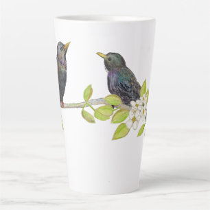 Zwei Starlings auf einem blühenden Zweig im Frühja Milchtasse