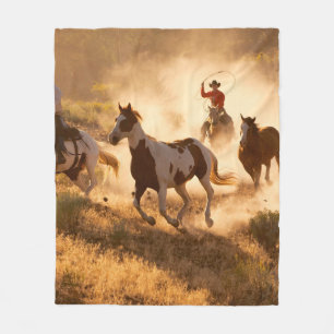 Zwei Western Cowboys reiten Pferde und springen wi Fleecedecke