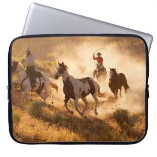 Zwei Western Cowboys reiten Pferde und springen wi Laptopschutzhülle