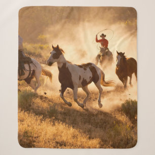 Zwei Western Cowboys reiten Pferde und springen wi Sherpadecke