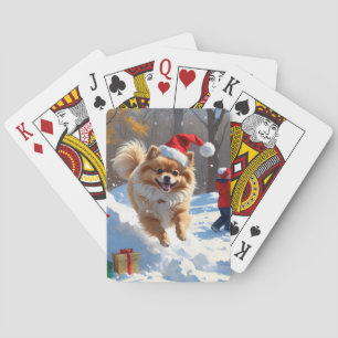 Zwergspitz läuft im Schnee mit Weihnachtsmütze Spielkarten